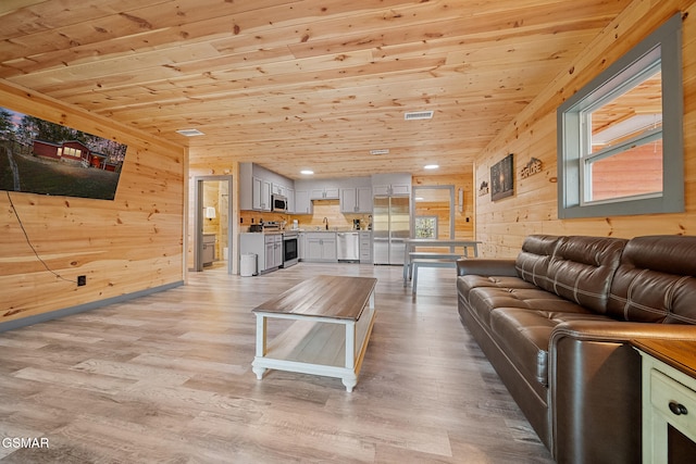 living room with light hardwood / wood-style floors, wood ceiling, and sink