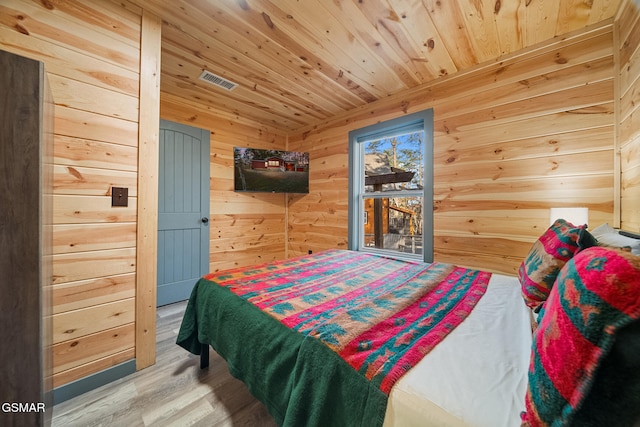 bedroom featuring wooden walls, wooden ceiling, and hardwood / wood-style flooring