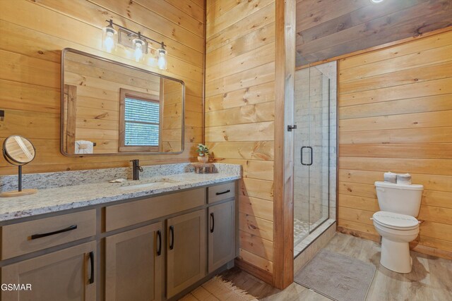 bathroom with hardwood / wood-style floors, vanity, walk in shower, and wood walls