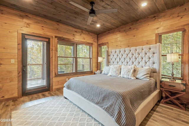 bedroom with wood walls, light hardwood / wood-style flooring, ceiling fan, and wooden ceiling