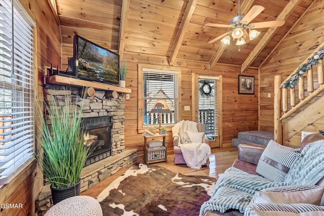 living area featuring lofted ceiling with beams, wooden ceiling, and wooden walls