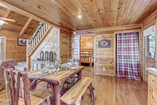 dining area with ceiling fan, wood walls, wood ceiling, stairs, and light wood finished floors