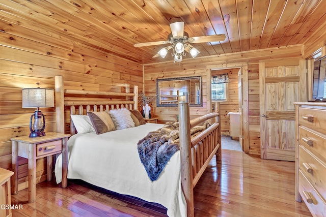 bedroom featuring wooden walls, wooden ceiling, and light wood-style floors