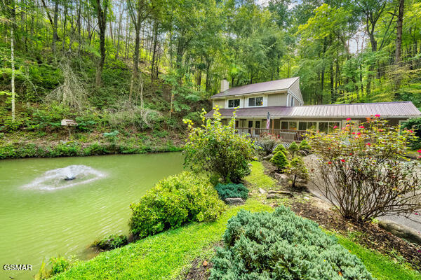 exterior space with a water view and a view of trees