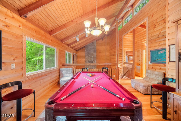 game room featuring lofted ceiling with beams, wooden ceiling, wood finished floors, pool table, and wood walls