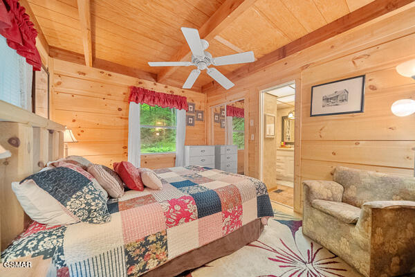 bedroom with wooden ceiling, wood walls, and beamed ceiling