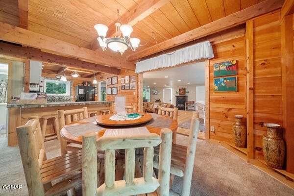 dining room with wood ceiling, wooden walls, beam ceiling, and an inviting chandelier