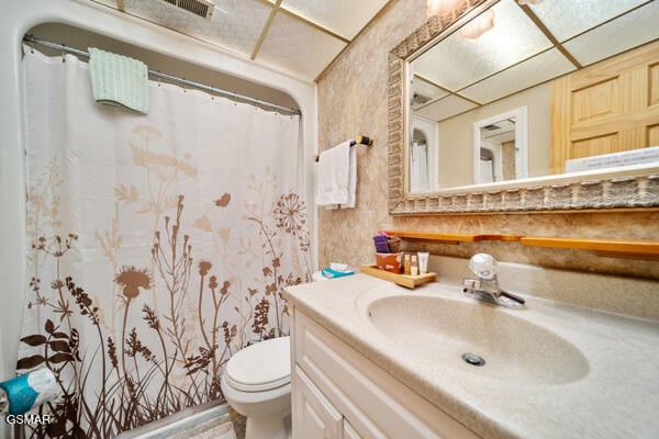 full bathroom featuring a shower with curtain, visible vents, vanity, and toilet