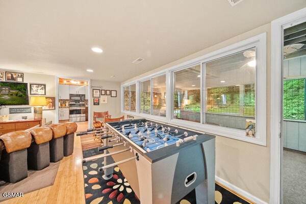 game room with recessed lighting and light wood finished floors