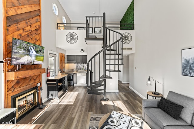 1260 Ski View Dr Unit 3308, Gatlinburg, TN 37738 - living area featuring dark wood-style flooring, a towering ceiling, baseboards, stairway, and a glass covered fireplace