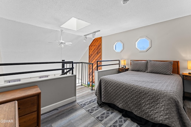 1260 Ski View Dr Unit 3308, Gatlinburg, TN 37738 - bedroom featuring lofted ceiling with skylight, a textured ceiling, track lighting, wood finished floors, and baseboards