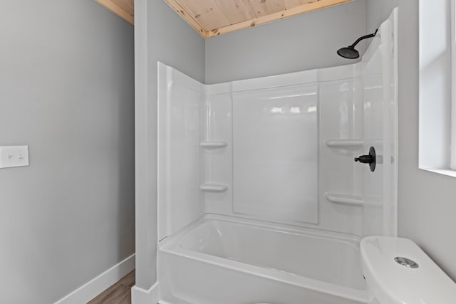 bathroom featuring  shower combination, hardwood / wood-style floors, wood ceiling, and toilet