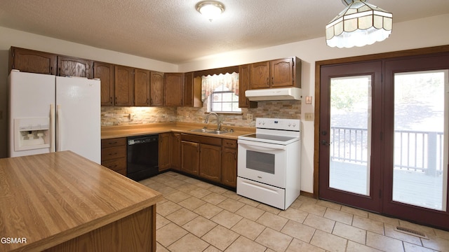 kitchen with tasteful backsplash, sink, white appliances, and decorative light fixtures