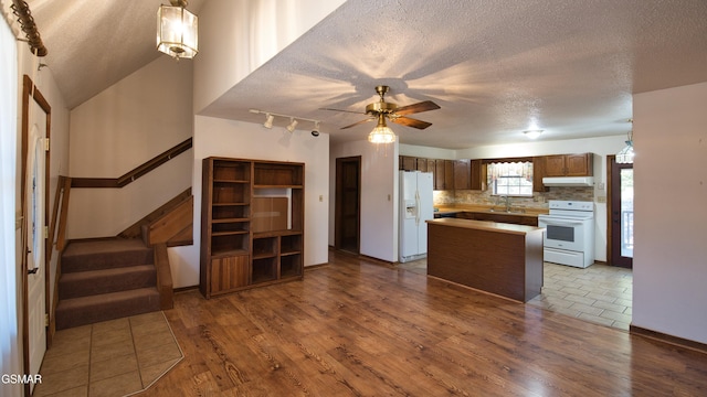 kitchen featuring tasteful backsplash, dark hardwood / wood-style flooring, a textured ceiling, and white appliances