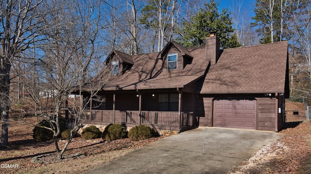 cape cod-style house featuring a garage and a porch