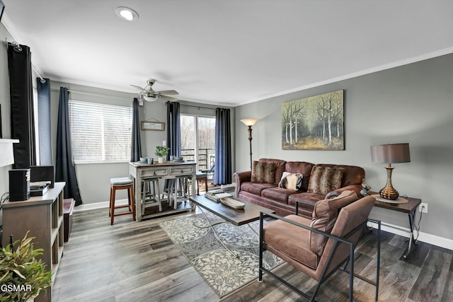 living room with ceiling fan, hardwood / wood-style flooring, crown molding, and a fireplace