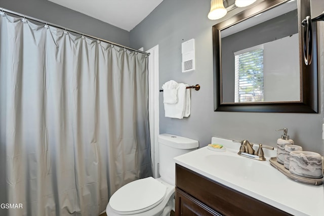 bathroom with toilet, vanity, and curtained shower