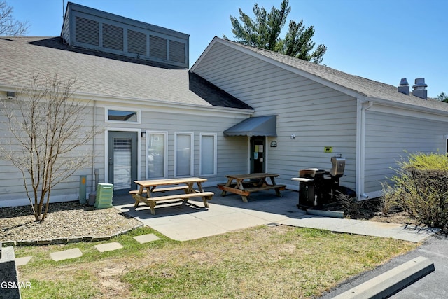 back of property featuring a lawn and a patio