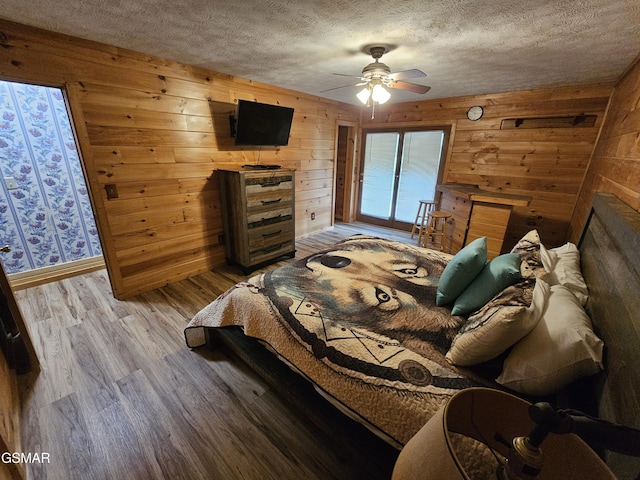 2114 Rabbit Point Way, Sevierville, TN 37876 - bedroom with wood walls, wood finished floors, a textured ceiling, and ceiling fan