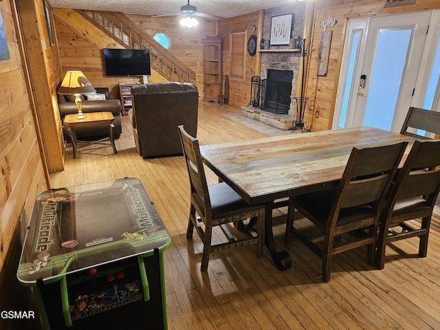 2114 Rabbit Point Way, Sevierville, TN 37876 - dining space featuring wood walls, wood-type flooring, a fireplace, and ceiling fan
