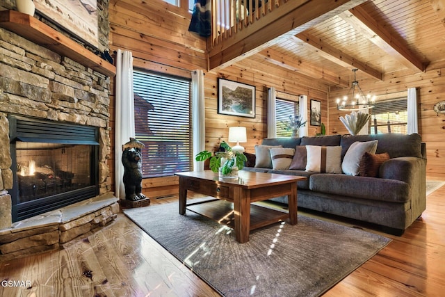 612 Cherry Blossom Way, Pigeon Forge, TN 37863 - living room with wood finished floors, an inviting chandelier, wooden walls, wood ceiling, and a stone fireplace