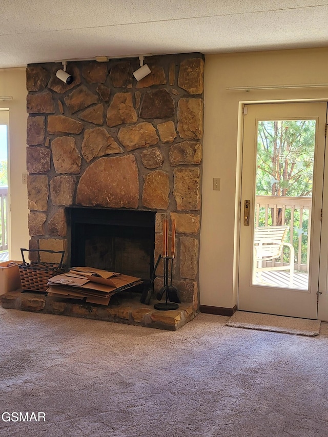 room details featuring a fireplace, carpet, and a textured ceiling