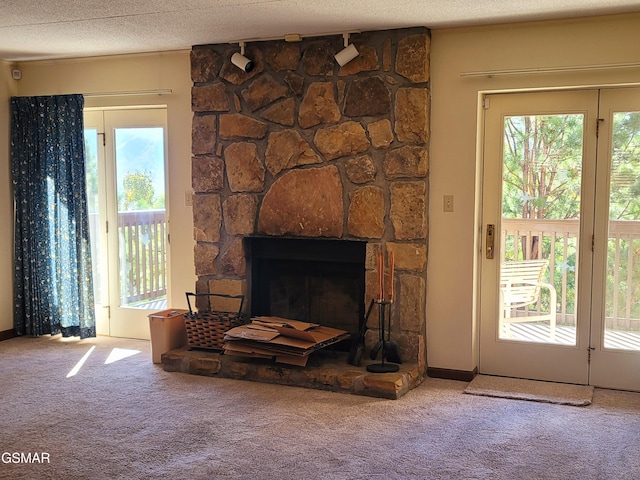 room details with a stone fireplace, carpet floors, and a textured ceiling