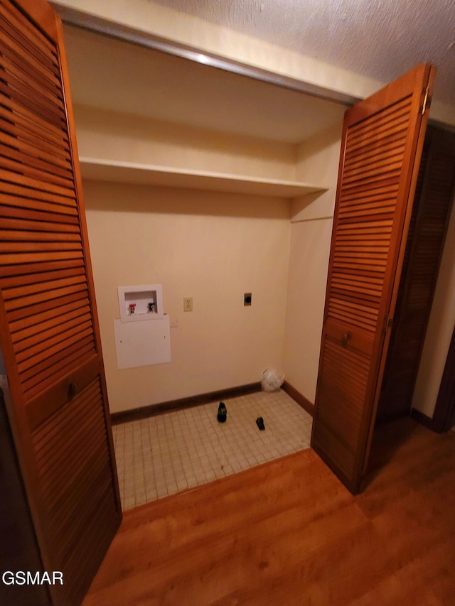 washroom featuring electric dryer hookup, hookup for a washing machine, a textured ceiling, and hardwood / wood-style flooring