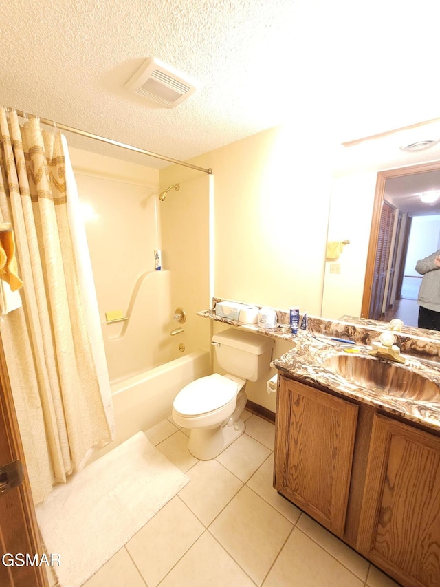 full bathroom with shower / bath combo, a textured ceiling, vanity, tile patterned flooring, and toilet