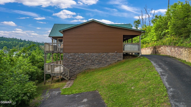 1792 Paulas Huskey Cir, Sevierville, TN 37876 - view of side of property with faux log siding, a yard, stone siding, asphalt driveway, and a balcony