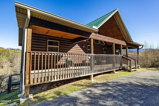 view of side of home featuring a porch and metal roof