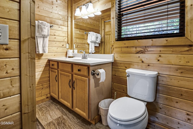 half bath with toilet, wooden walls, and vanity