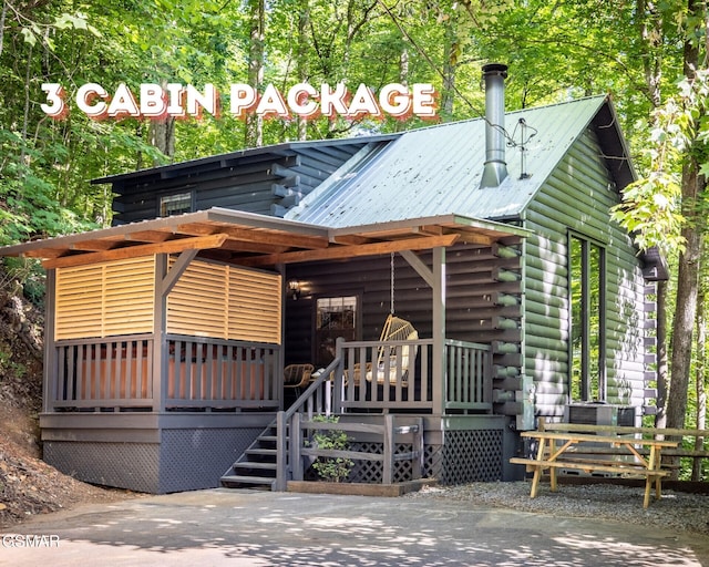 view of front of home with log exterior and metal roof