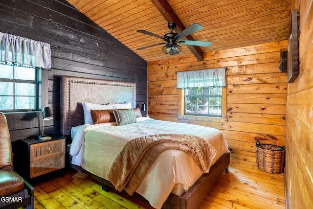 bedroom with lofted ceiling with beams, wood walls, ceiling fan, wood ceiling, and hardwood / wood-style flooring