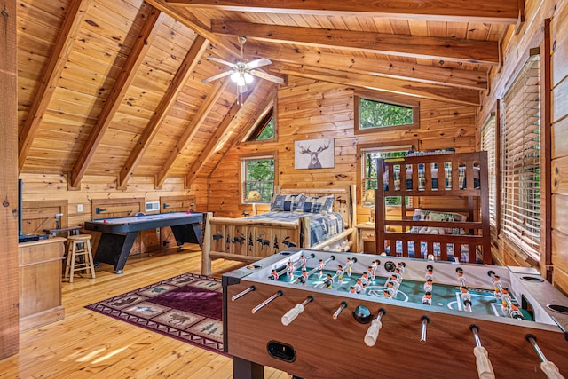 rec room with ceiling fan, wooden ceiling, beamed ceiling, wooden walls, and hardwood / wood-style flooring