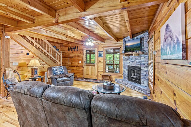 living room featuring beamed ceiling, ceiling fan, wood ceiling, and wooden walls