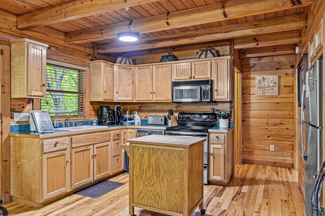 kitchen featuring a center island, sink, wooden walls, light brown cabinetry, and appliances with stainless steel finishes