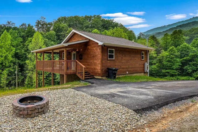 exterior space featuring a mountain view, a porch, and an outdoor fire pit