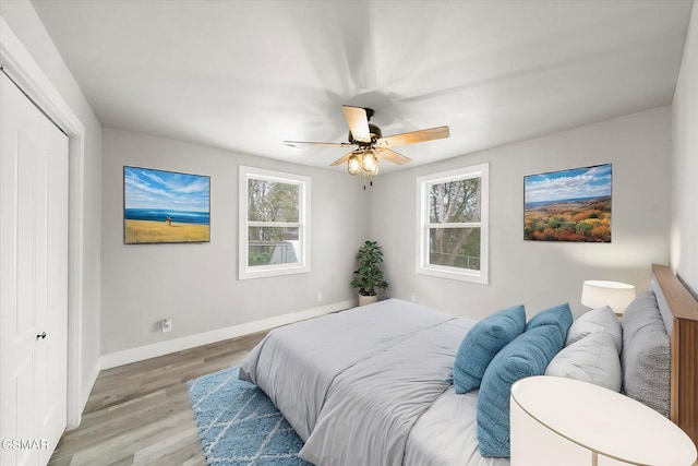 bedroom featuring ceiling fan, a closet, and light hardwood / wood-style flooring