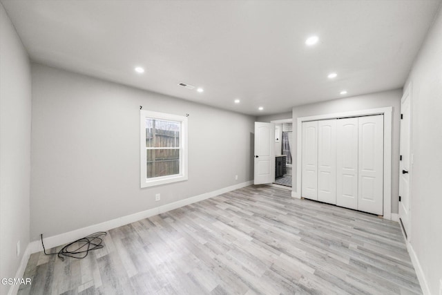 unfurnished bedroom featuring light wood-type flooring and a closet