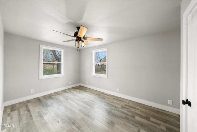 empty room with hardwood / wood-style floors, plenty of natural light, and ceiling fan