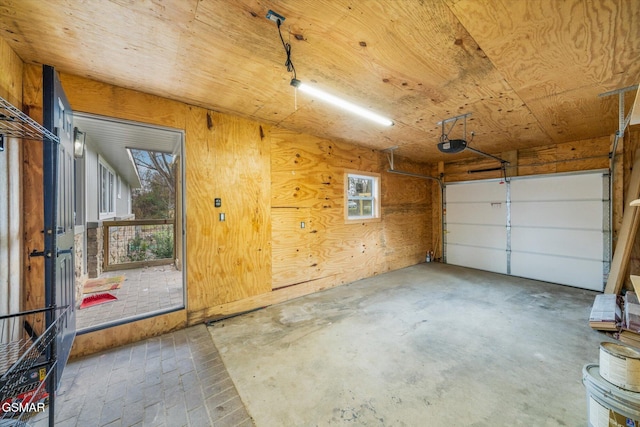 garage featuring wood walls and a garage door opener