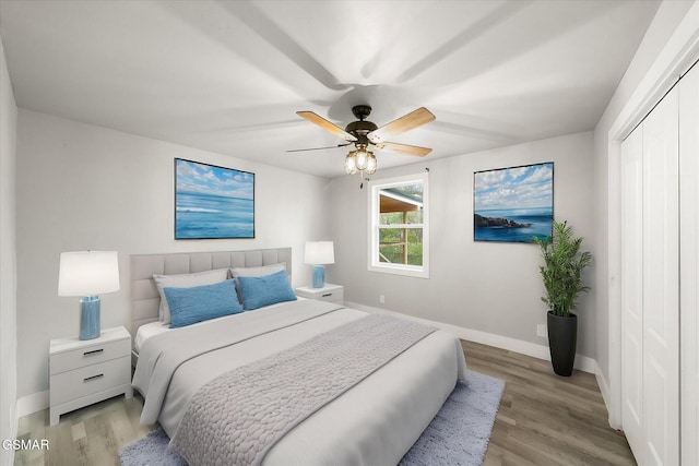 bedroom with a closet, light hardwood / wood-style flooring, and ceiling fan