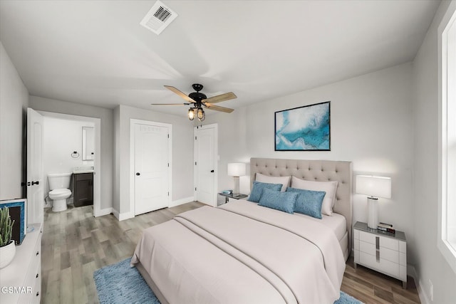 bedroom featuring wood-type flooring, ensuite bath, and ceiling fan