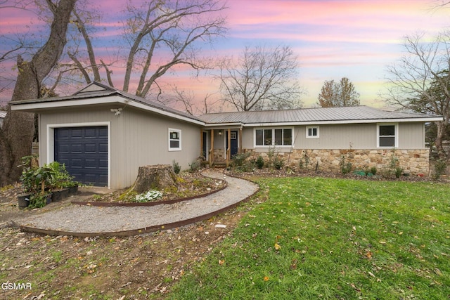 ranch-style home featuring a yard and a garage