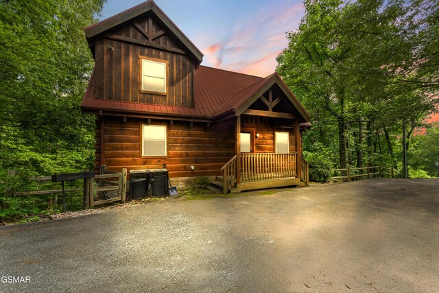 rustic home with metal roof and fence
