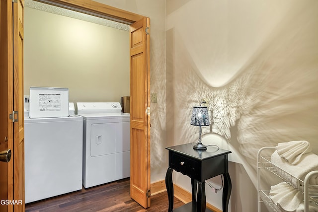 clothes washing area with washer and dryer and dark wood-style flooring
