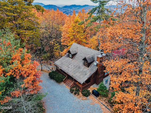 view of subject property featuring a heavily wooded area and a mountain backdrop