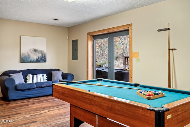 game room with wood finished floors, billiards, a textured ceiling, electric panel, and french doors