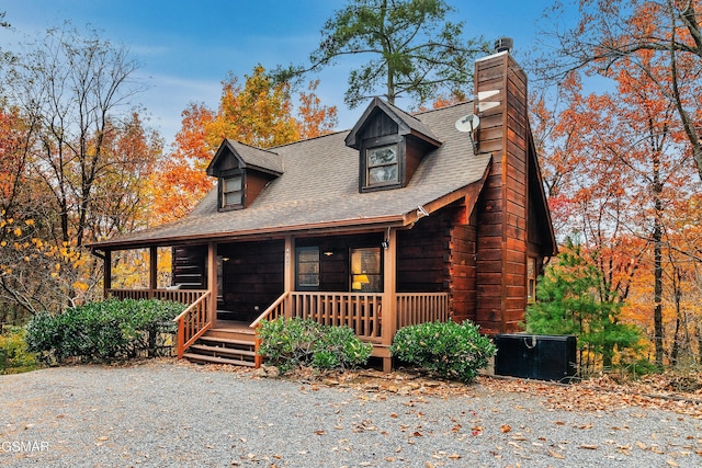 view of front of property featuring a porch, a chimney, and roof with shingles